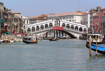 The Rialto Bridge is crossing the Grand Canal